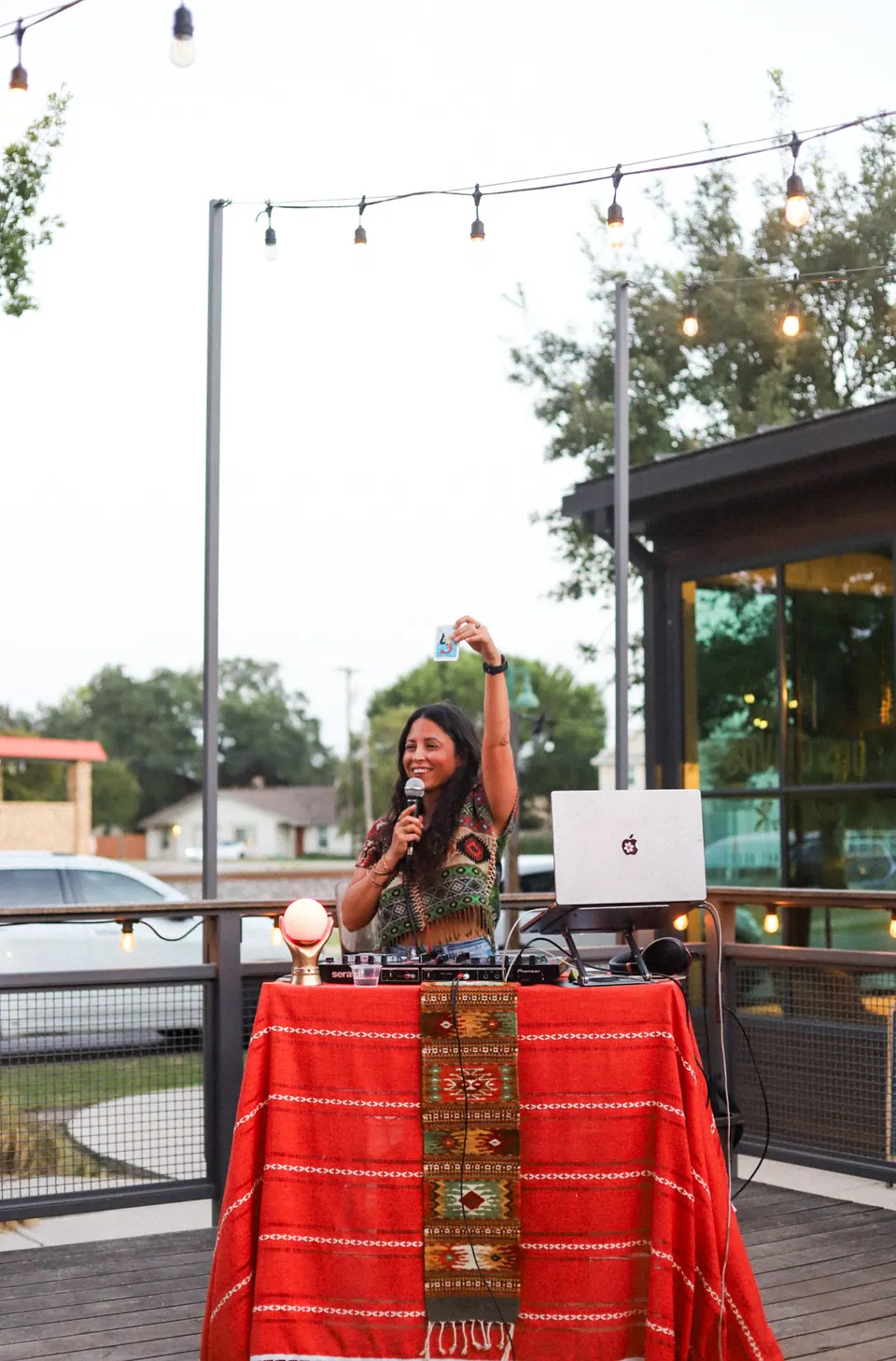 An event host with a microphone and music equipment on a patio