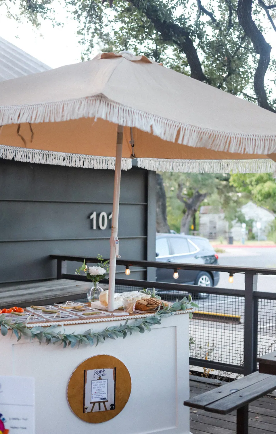 A refreshment cart with greenery at an outdoor gathering